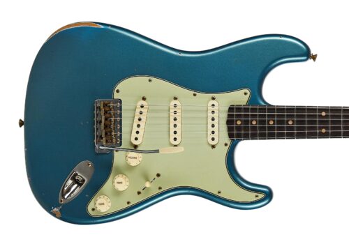 Blue electric guitar body with cream pickguard, visible wear and scratches on a teal finish (partial view).